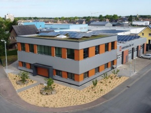 Blick auf Neubau mit Dachbegrünung und Photovoltaik